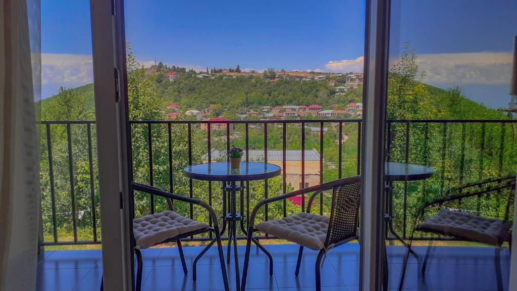 西格纳吉Guest House Maradona的设有一个配有桌子和两把椅子的阳台,并享有美景。