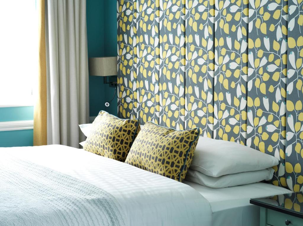 瑟勒斯Hayes Hotel的一间卧室配有一张蓝色和黄色壁纸的床