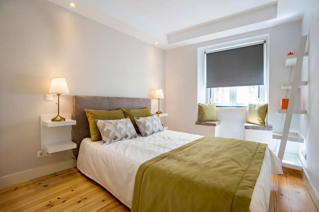里斯本阿尔法马顶峰公寓的一间卧室设有一张大床和一个窗户。