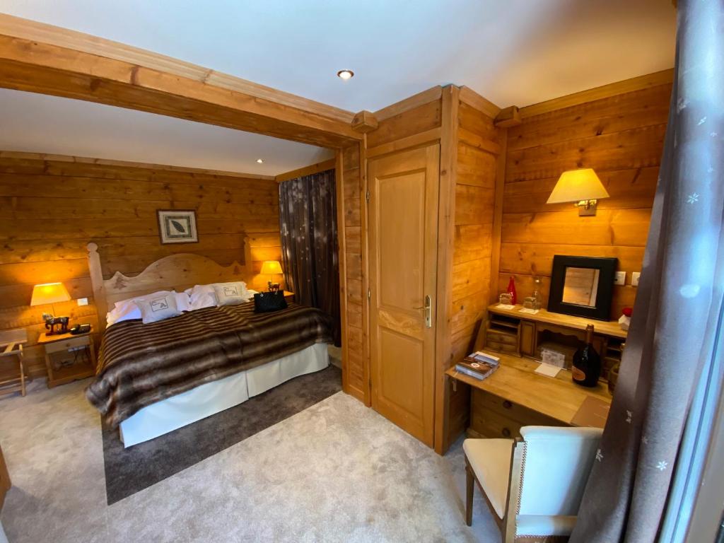 欧龙欧龙木屋酒店的一间卧室配有一张床和一张书桌及电视
