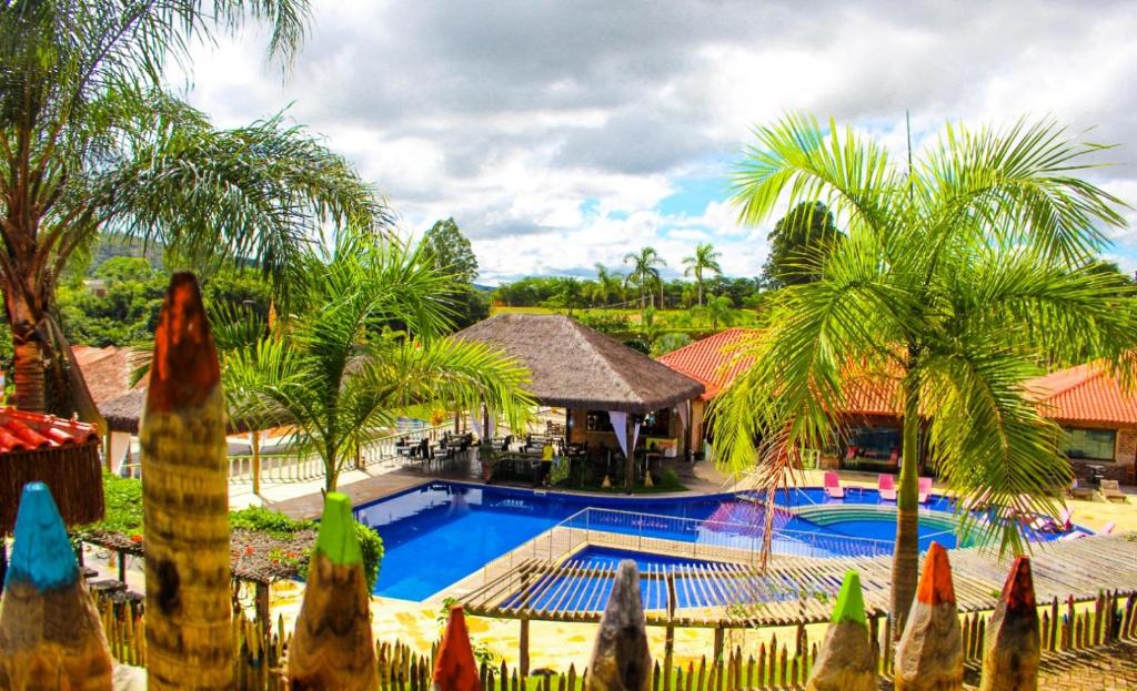 埃斯梅拉达斯Parque Do Avestruz Eco Resort的一个带游泳池和棕榈树的度假村