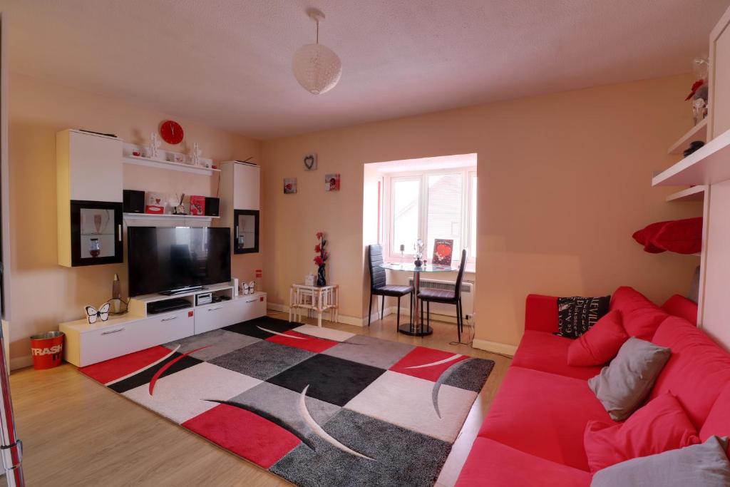 NortholtLuxury Studio Apartment的客厅配有红色沙发和电视