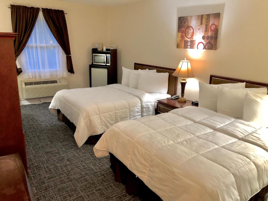 BuckhannonBicentennial Inn的酒店客房设有两张床和窗户。