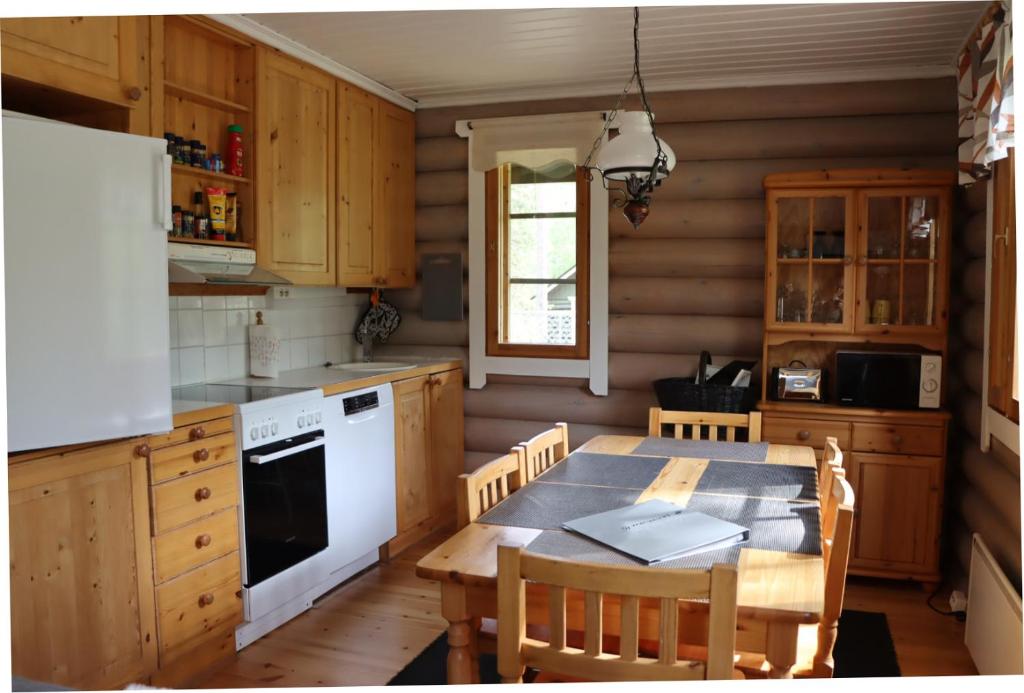 锡尔卡Levihaukka 10的厨房配有桌子和白色冰箱。