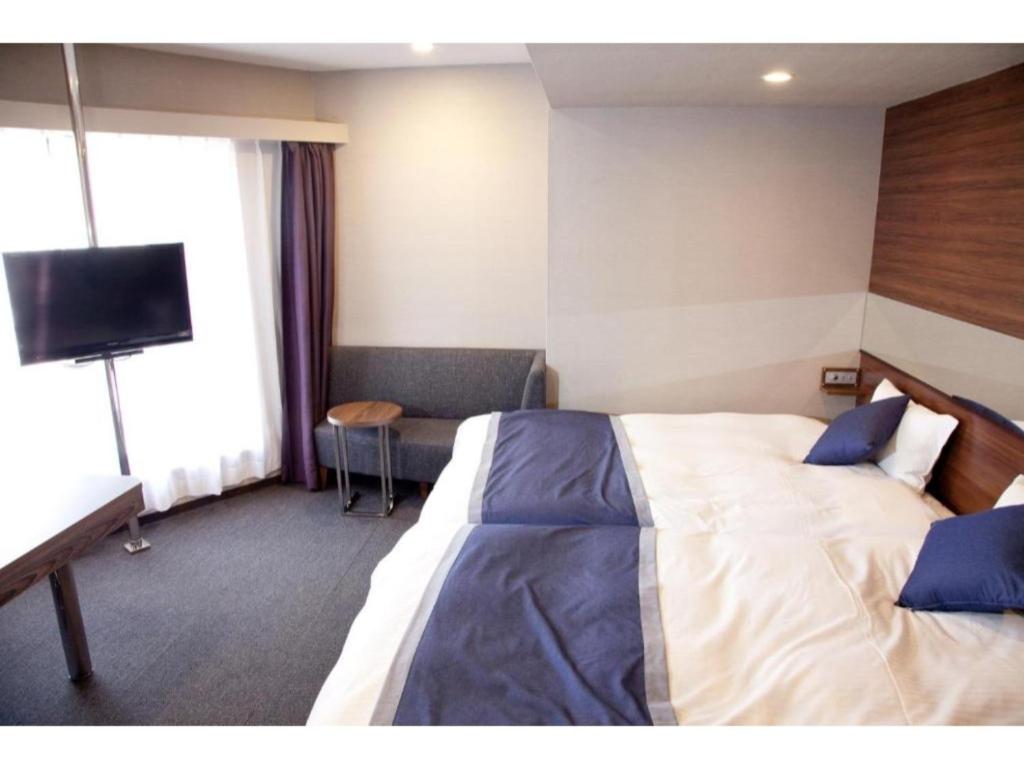 岐阜Hotel Il Credo Gifu - Vacation STAY 84631的配有一张床和一台平面电视的酒店客房