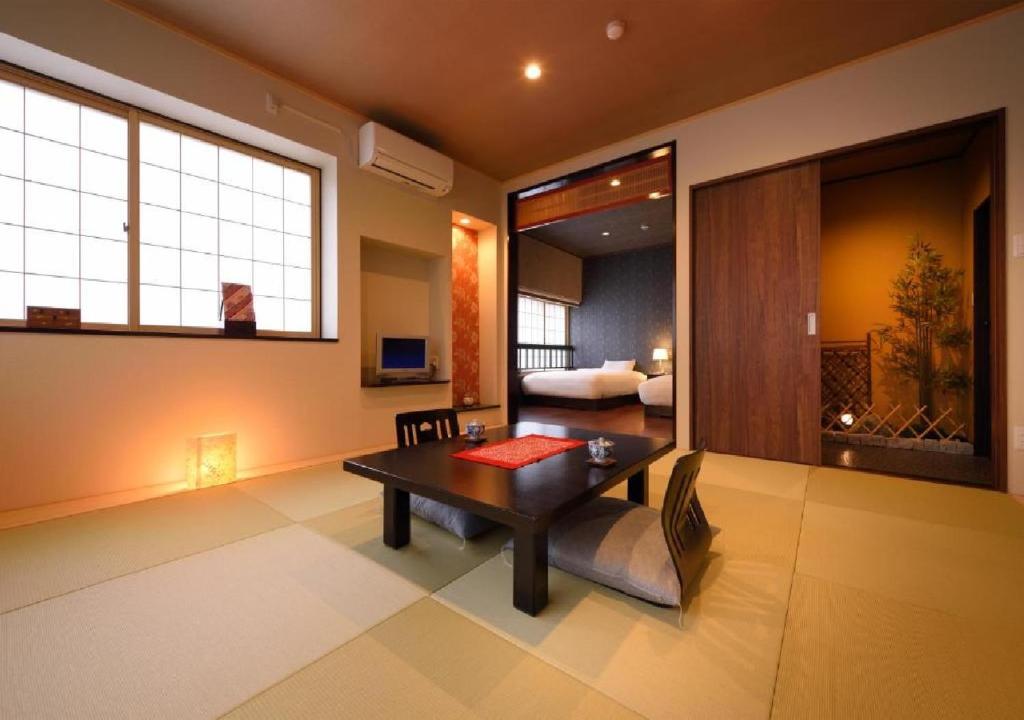 花卷市Dai Onsen Matsudaya Ryokan - Vacation STAY 67479的一间带桌子的客厅和一间卧室