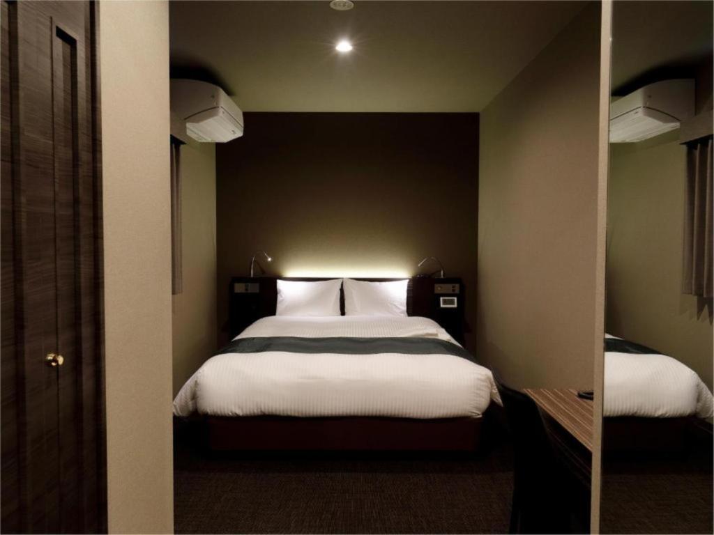 东京Act Hotel Roppongi - Vacation STAY 84276的一间卧室配有一张带镜子的大床