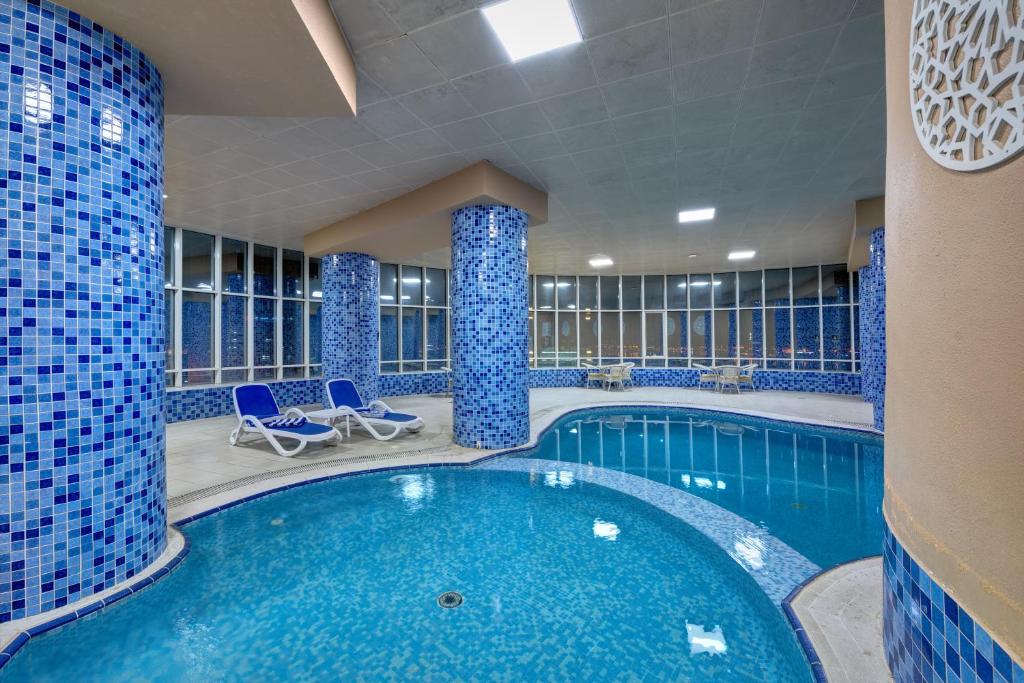 沙迦阿雅那酒店的蓝色瓷砖的酒店游泳池