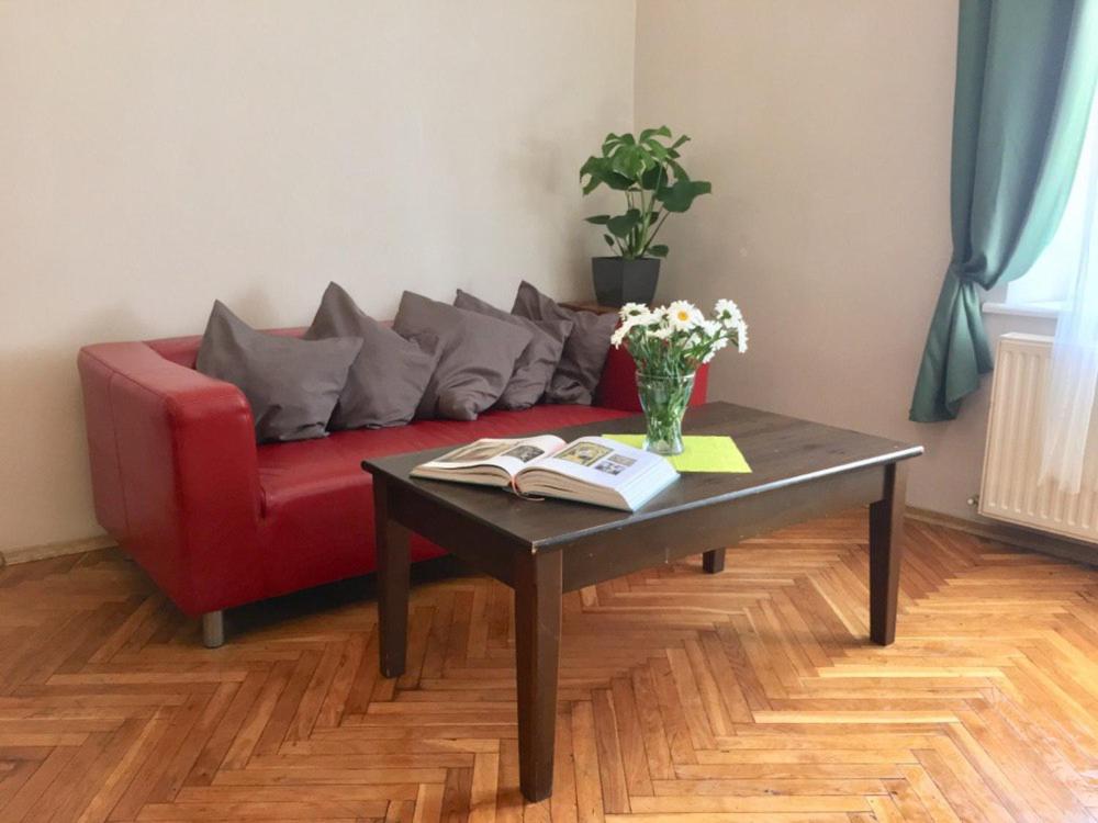 克拉科夫Green House的客厅配有红色沙发和茶几