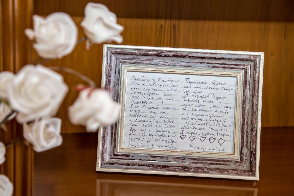 KhatzirádhosXατζηράδος的一张白玫瑰花框中的字母图