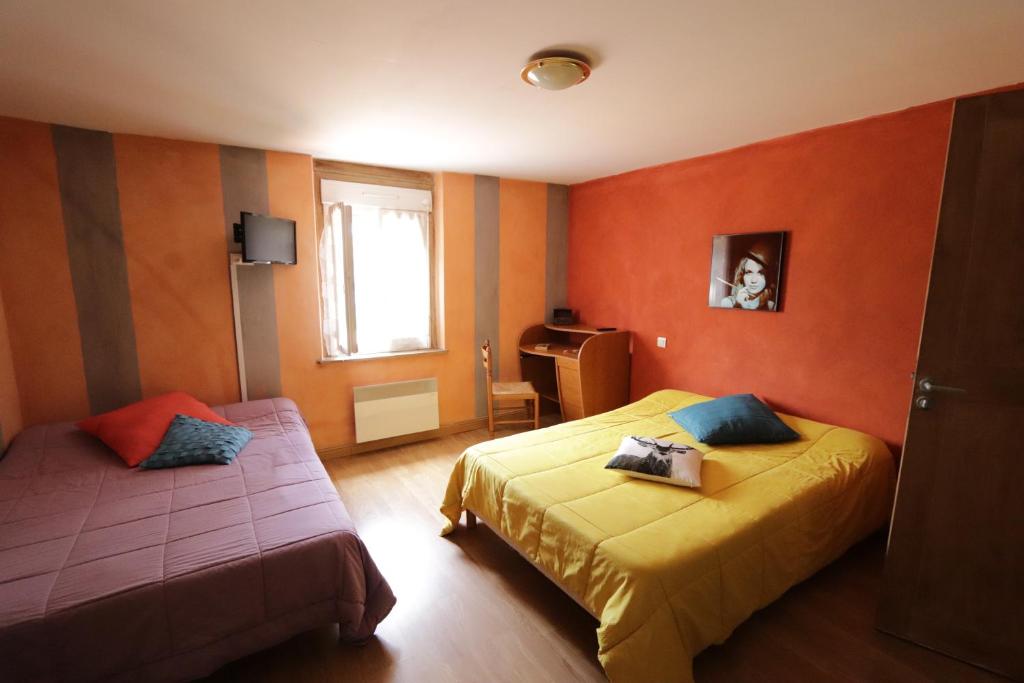 TosseLe Ptit Ecureuil的橙色墙壁客房的两张床