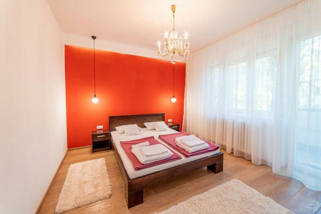 诺维萨德Apartman Danube lux的一间卧室配有一张红色墙壁的床