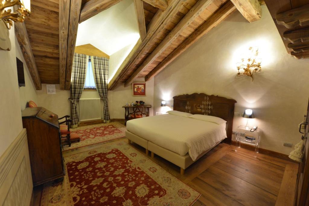 奥斯塔勒里弗查芒特酒店的一间卧室设有一张大床和木制天花板。