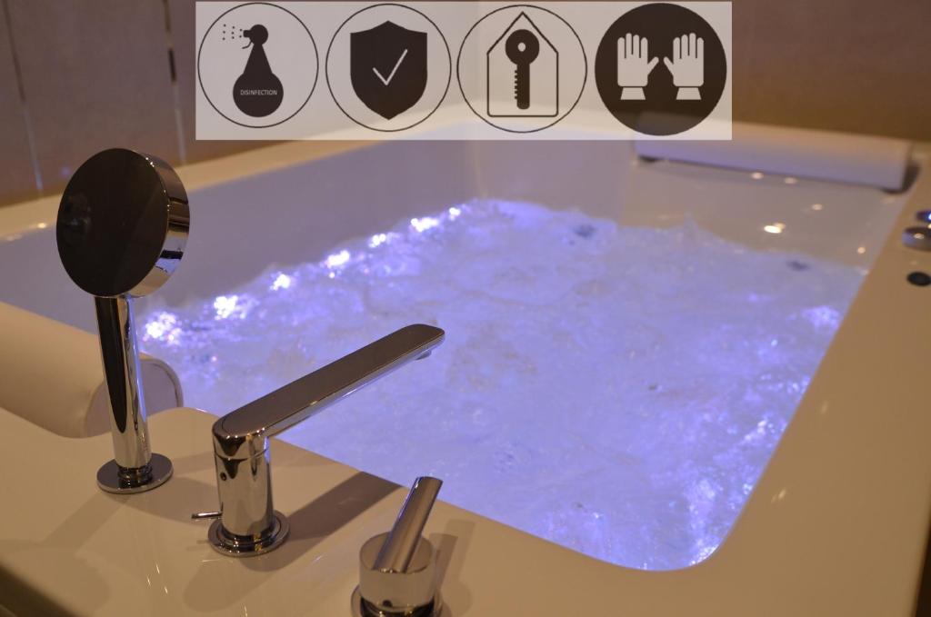 克拉科夫Jacuzzi Apartments的浴室配有充满蓝色水的浴缸。