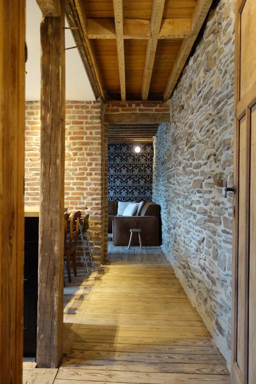斯帕Gîtes le second à Spa (gîte de 2 et de 5 personnes)的一间设有石墙和木走廊的房间