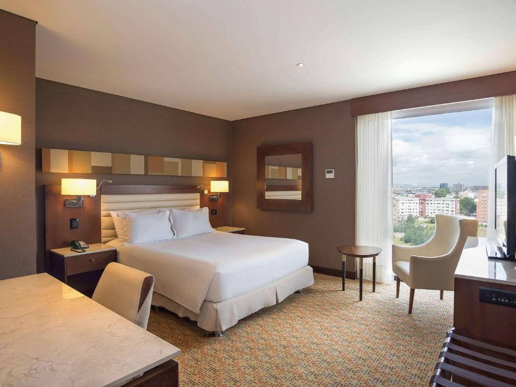 波哥大Mercure Bogota Calle 100的酒店客房设有一张床和一个大窗户