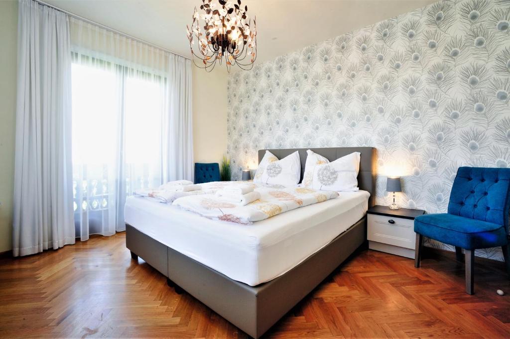 巴特塔茨曼斯多夫贝德塔茨曼斯得福马尔蒂尼霍夫酒店的一间卧室配有一张大床和一张蓝色椅子
