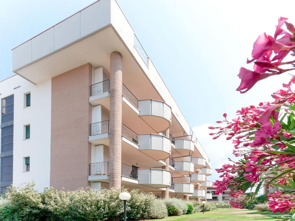 圣温琴佐Apartment Superior-4 by Interhome的一座高大的公寓楼,前面有粉红色的鲜花