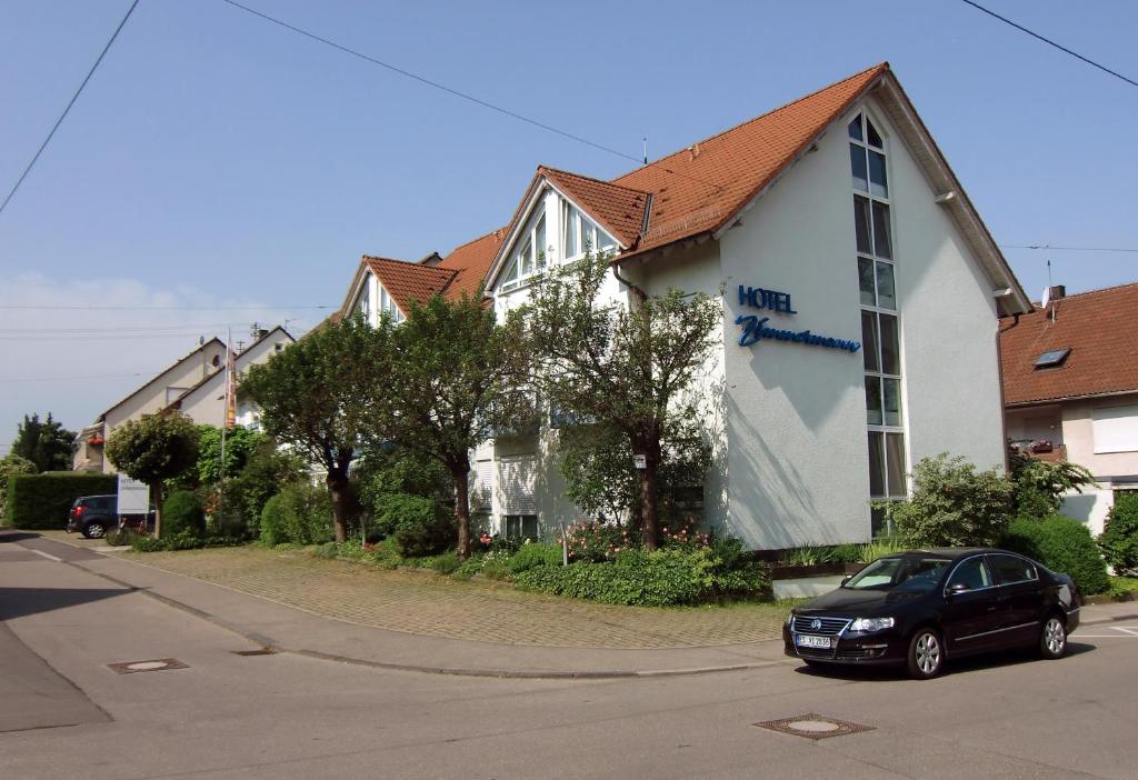 菲尔德施塔特兹莫尔曼酒店的停在房子前面的一辆黑色汽车