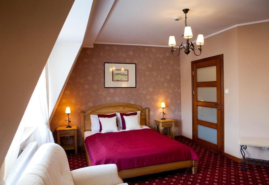 卡尔图济Hotel i Restauracja "Pod Orłem"的一间卧室配有一张红色床罩的床