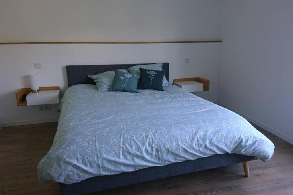 Saint-Fortunat-sur-EyrieuxGîte de charme en Ardèche : vue panoramique, plage privée的一间卧室配有一张带蓝色床单和枕头的床。