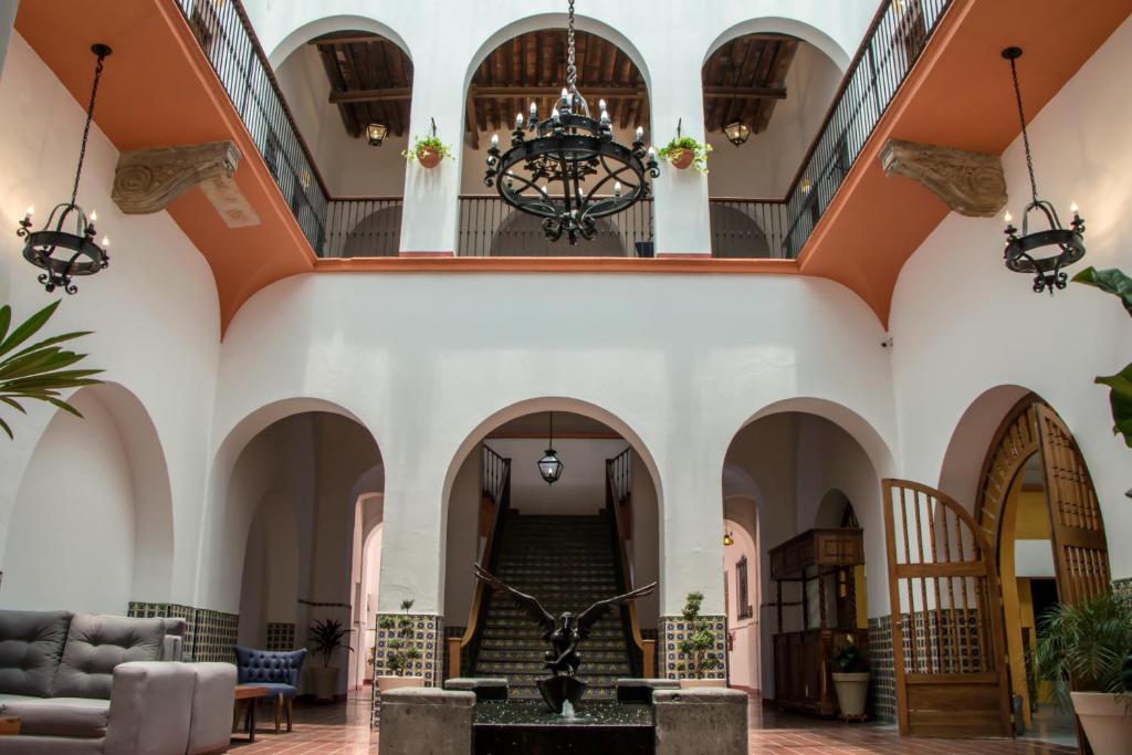 瓜达拉哈拉Hotel Real de Castilla Colonial的一个大大堂,设有楼梯和吊灯