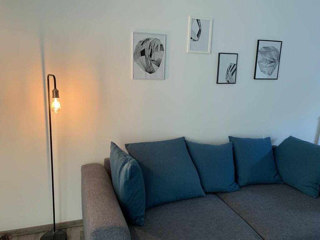 FrensdorfGroßes, modernes Apartment im Souterrain的客厅里一张蓝色的沙发,墙上挂着照片