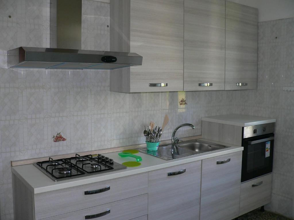阿曼泰阿GP casa vacanza Amantea的厨房配有水槽和炉灶 顶部烤箱