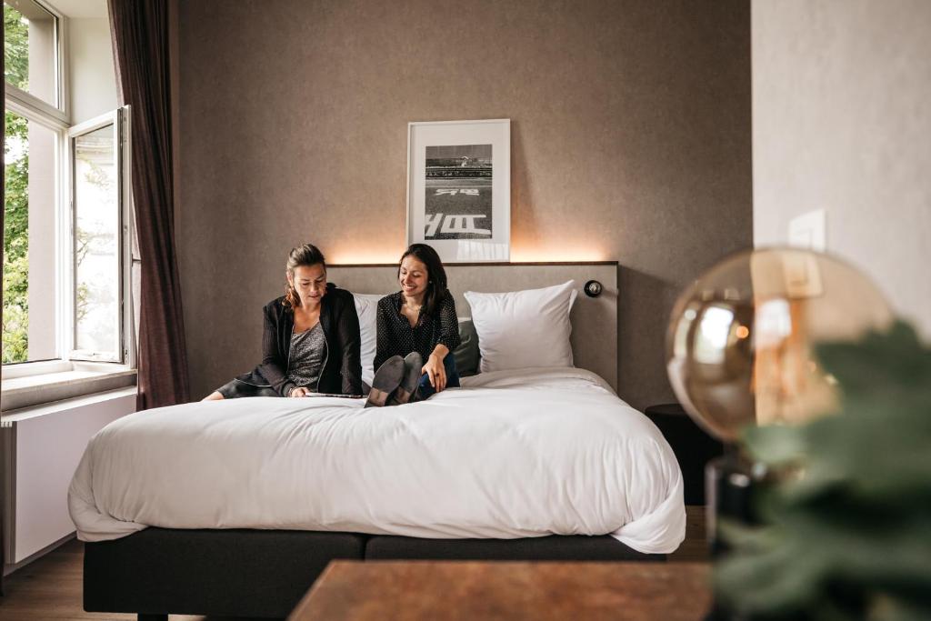 布鲁日莫里斯先生酒店的两名妇女坐在床上