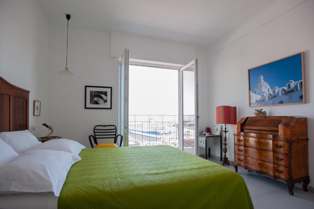 那不勒斯B&B ICHOME NAPOLI - Maison d'Artiste的一间卧室设有一张绿色的床和一个大窗户