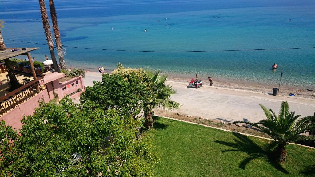 Flámbourasxanthi's sea front villas的和水中的人一起欣赏海滩的景色