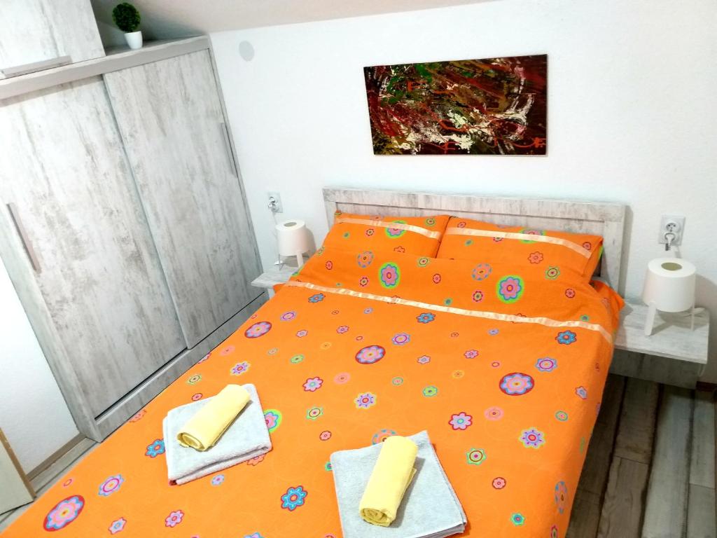 索科矿泉村Apartmani Java的一间卧室配有橙色床和2条毛巾