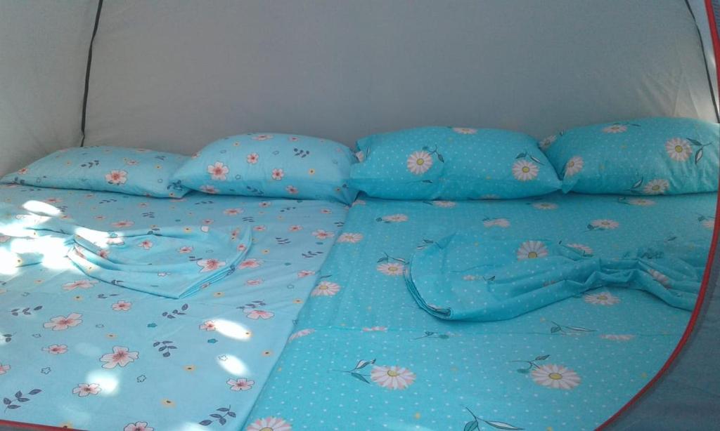 博尔什Camping Jungle in Borsh的一张带蓝色床单和蓝色枕头的床