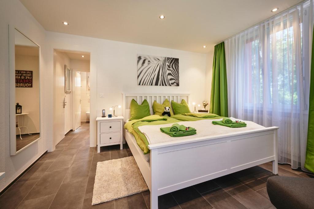 伯尔尼da Maurizio Suites的卧室配有带绿色枕头的大型白色床