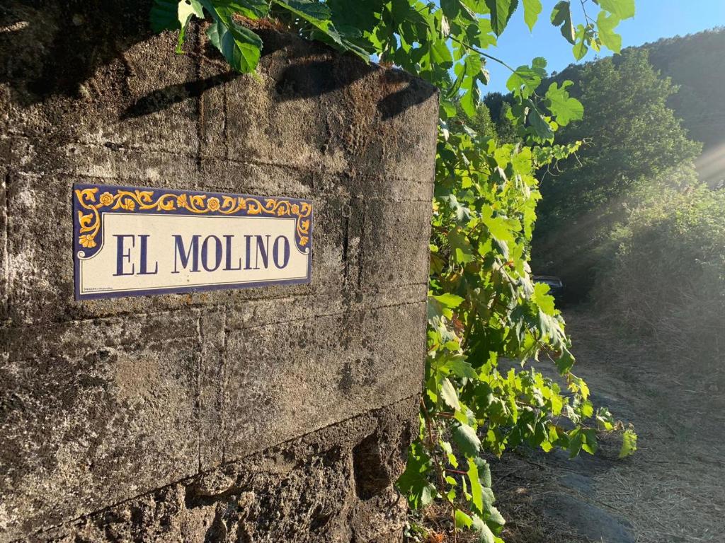 GavilanesCasa Rural El Molino的石墙上的一个标志,上面写着马洛