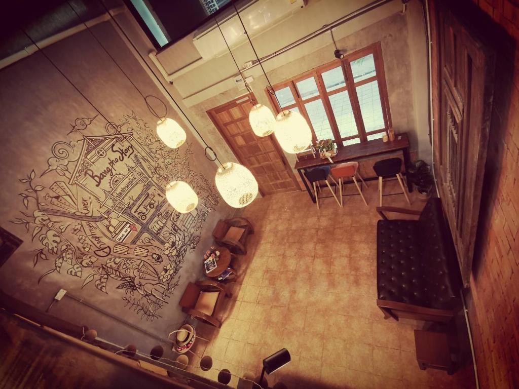 曼谷Bangpho Story的享有带桌椅的客厅的顶部景色。