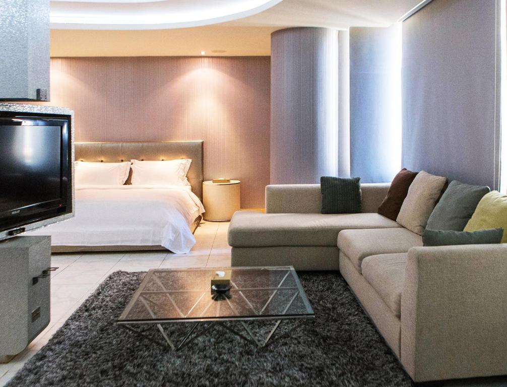 竹山欧游国际连锁精品旅馆的酒店客房配有床、沙发和电视。