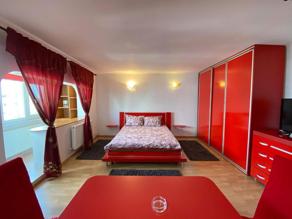 康斯坦察Faleză nord的一间卧室配有红色的床和红色橱柜