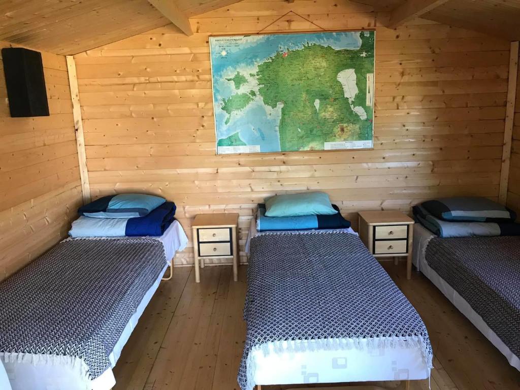 派德Sillaotsa camp的一间设有三张床的客房,墙上有一张地图