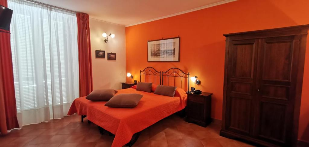 那不勒斯尼亚波利酒店的一间卧室配有一张橙色墙壁的床