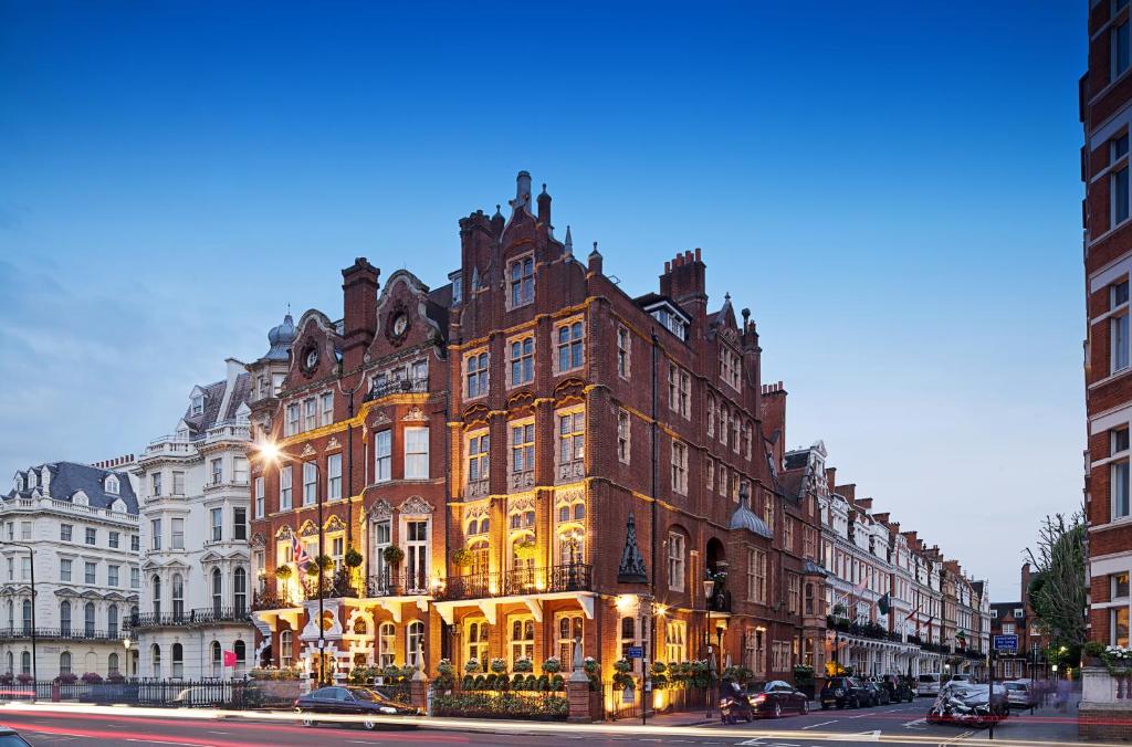 伦敦红色康乃馨肯辛顿里程碑酒店的城市街道上一座大型砖砌建筑