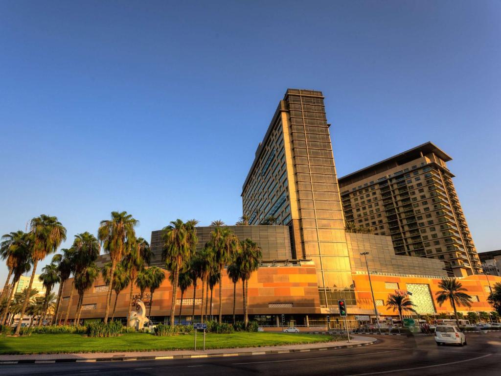迪拜迪拜古赖尔瑞士酒店的一座棕榈树环绕的大建筑