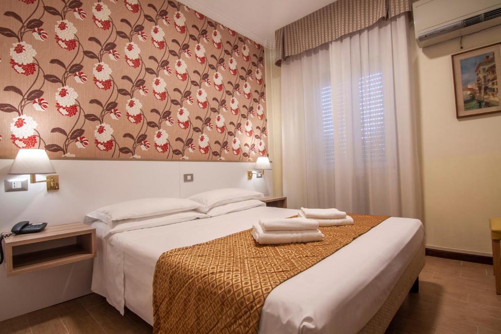 米兰笛费欧里酒店的一间卧室设有两张床和花卉墙