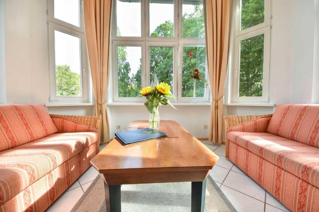 黑灵斯多夫Villa Hohe Düne 06的客厅设有两张沙发和一张带鲜花的桌子