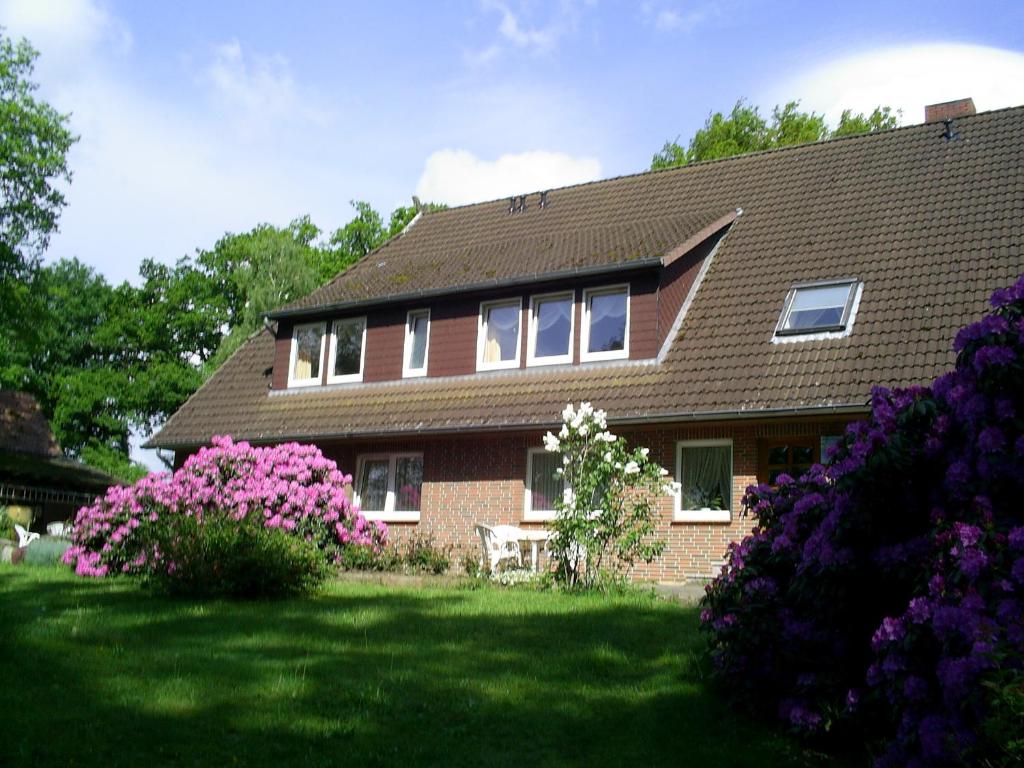 BehringenRhododendronhof的院子里有粉红色花的房子
