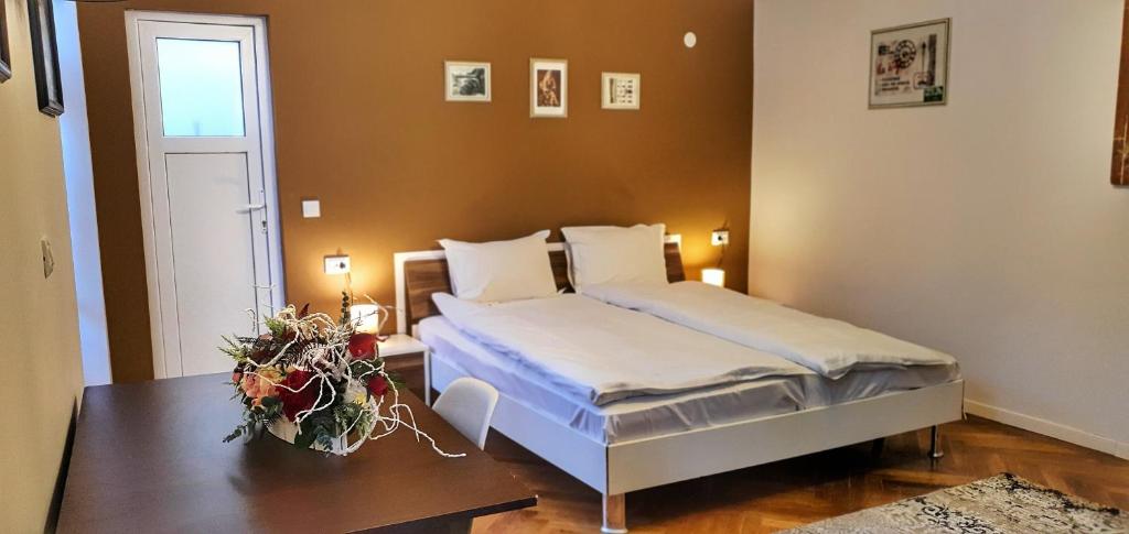 布拉索夫Casa Crown的一间卧室配有一张床和一张鲜花桌子