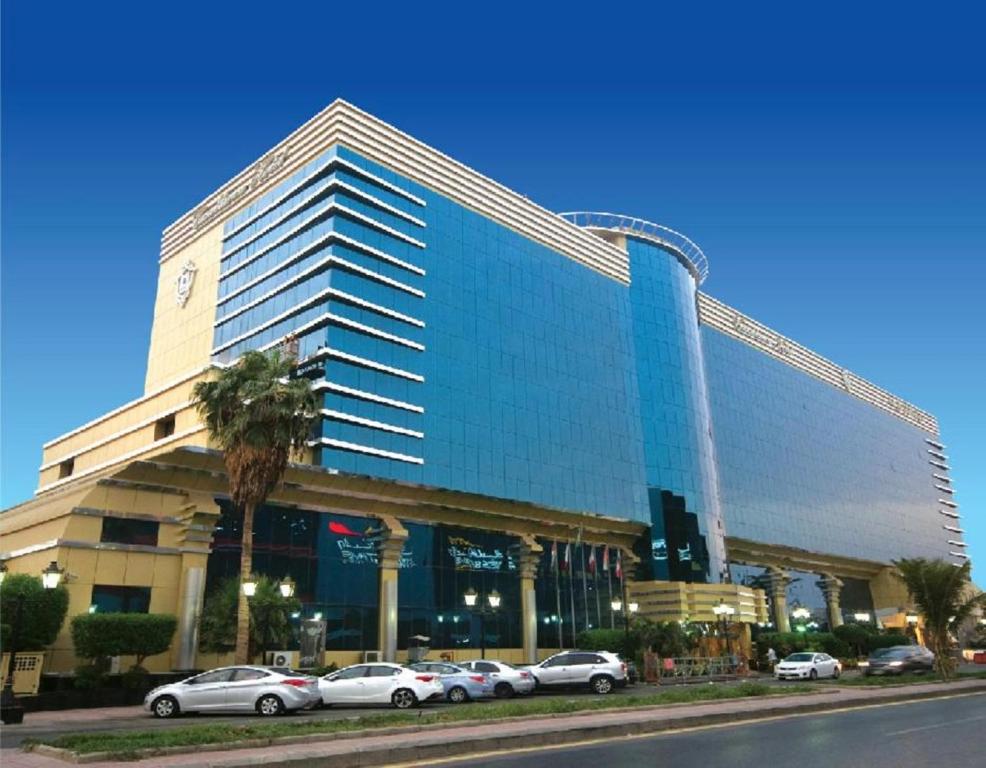 吉达吉达卡萨布兰卡酒店的一座大型建筑,前面有汽车停放