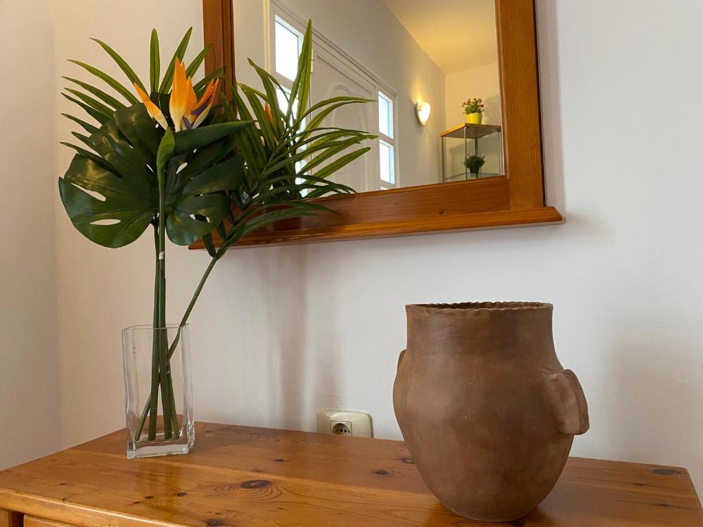 La HidalgaCasa Mariet的坐在木桌边的花瓶,带镜子