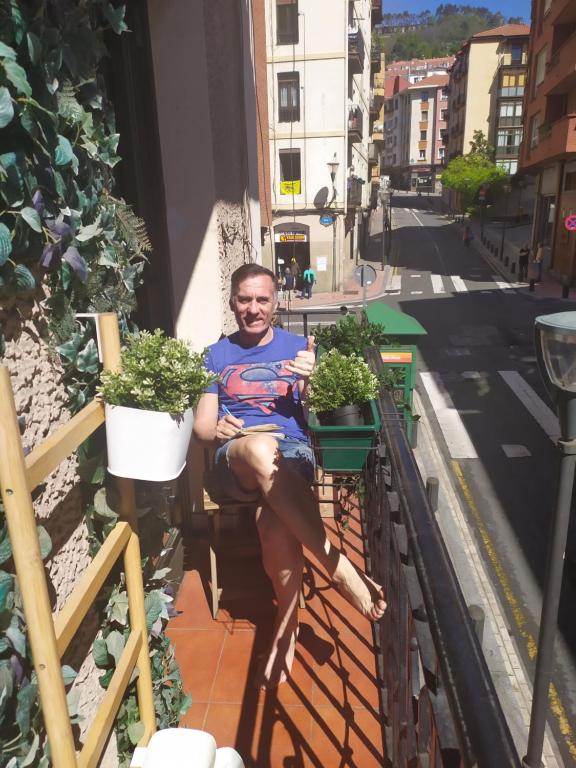 毕尔巴鄂Bilbao Center Apt PARKING的坐在植物阳台的人