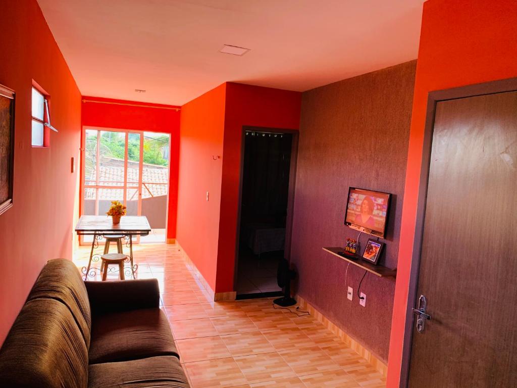 格拉瓦塔Casa em Gravata mobiliada的客厅设有红色的墙壁、一张沙发和一张桌子